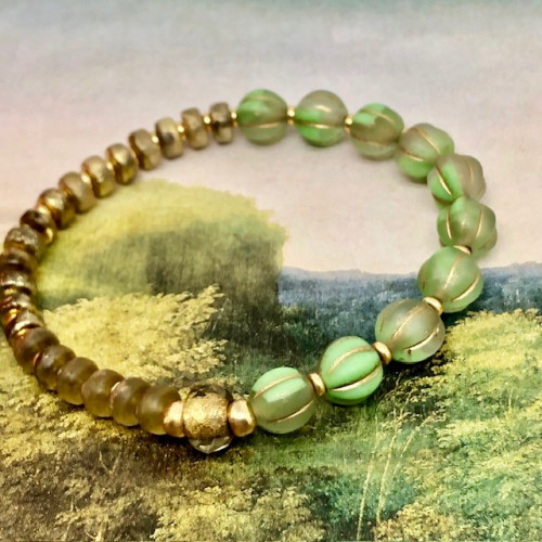 Bracelet élastique asymétrique bohème chic composé de perles en verre de Bohême vert pomme et bronze or. Bracelet stretch de créateur.