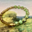 Bracelet élastique asymétrique bohème chic composé de perles en verre de Bohême vert pomme et bronze or. Bracelet stretch de créateur.