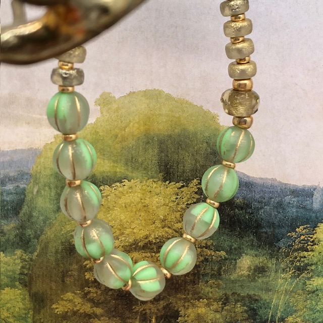 Bracelet élastique asymétrique bohème chic composé de perles en verre de Bohême vert pomme et bronze or. Bracelet stretch de créateur.