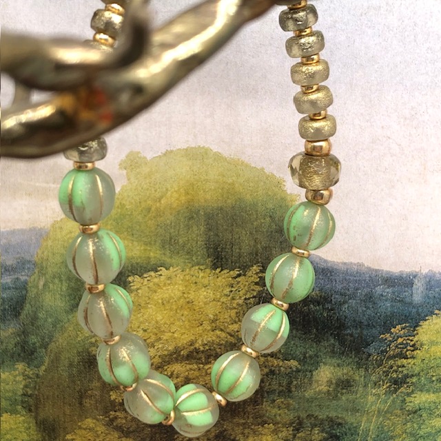 Bracelet élastique asymétrique bohème chic composé de perles en verre de Bohême vert pomme et bronze or. Bracelet stretch de créateur.