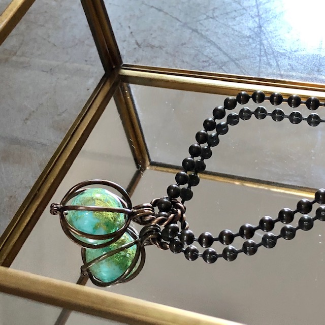Collier composé d'un pendentif cage en laiton et d’une perle de Murano. Chaîne en laiton. Pièce unique.