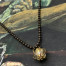 Collier ras-de-cou composé d’un pendentif cage en laiton et d’une perle de Murano dorée avec des paillettes argentées. Bijou unique.