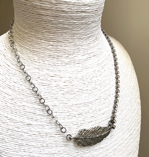 Collier composé d'un pendentif artisanal en étain et de deux chaînes, l''une incrustée de cristaux Swarovski et l'autre en Argent vieilli. Pièce unique.