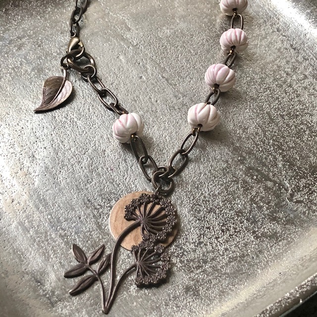 Collier composé d'un pendentif en laiton en forme de fleur et de perles artisanales en céramique rose pâle. Composants en laiton. Pièce unique.