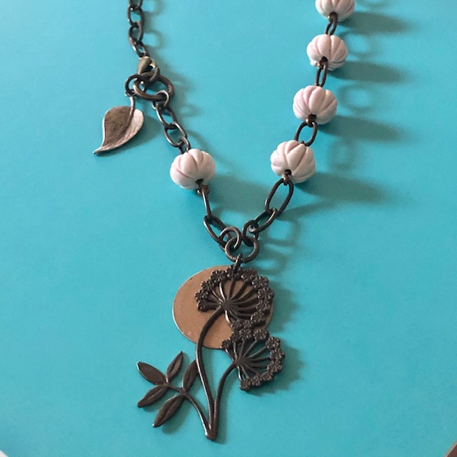 Collier composé d'un pendentif en laiton en forme de fleur et de perles artisanales en céramique rose pâle. Composants en laiton. Pièce unique.