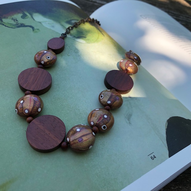 Collier composé de perles artisanales en pâte polymère, de perles en bois de Bayong et d'un chaîne en laiton. Pièce unique.