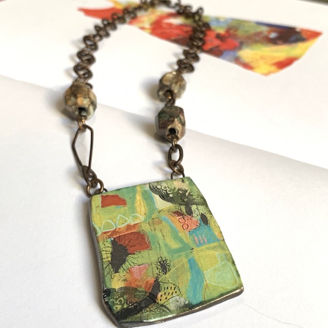 collier composé d’un magnifique pendentif artisanal et de perles facettées en céramique. Chaîne et fermoir en laiton