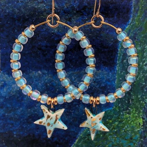 Créoles bleu ciel composées de perles de rocaille japonaises et d'une breloque en céramique en forme d'étoile. Bijoux bohèmes de créateur.