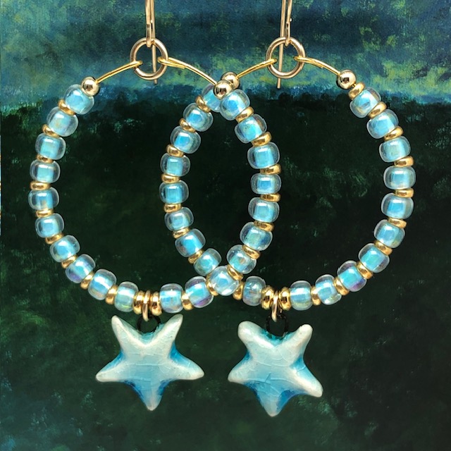 Créoles bleu ciel composées de perles de rocaille japonaises et d'une breloque en céramique en forme d'étoile. Bijoux bohèmes de créateur.