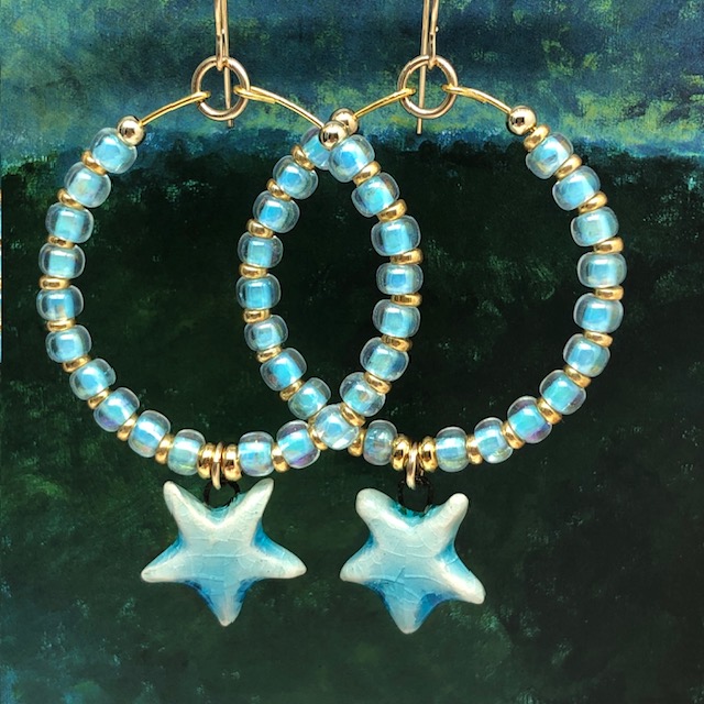 Créoles bleu ciel composées de perles de rocaille japonaises et d'une breloque en céramique en forme d'étoile. Bijoux bohèmes de créateur.