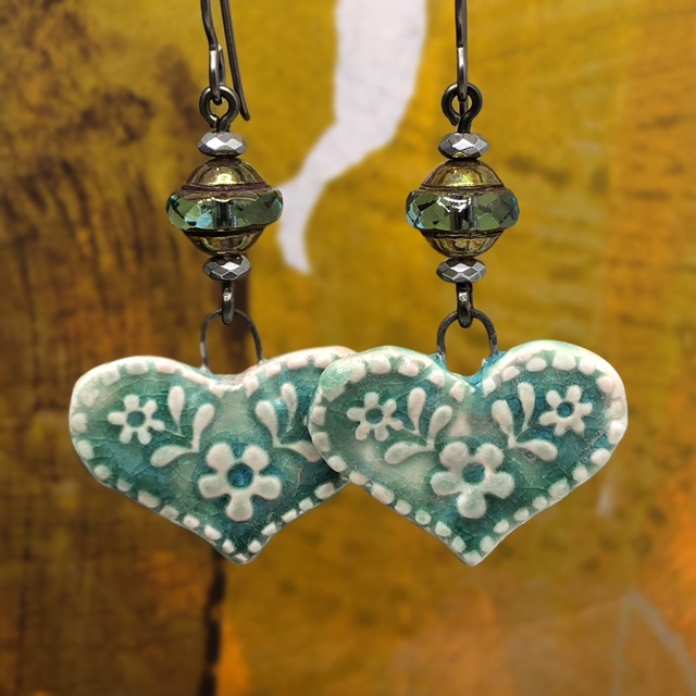 Boucles d'oreilles bohème en forme de coeur vert tendre composées de pendentifs en céramique et de perles tchèques.