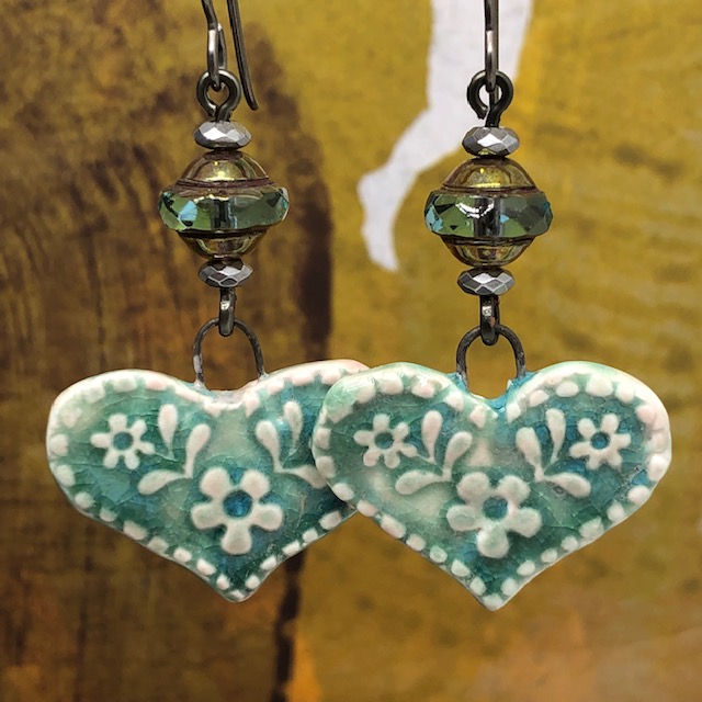Boucles d'oreilles bohème en forme de coeur vert tendre composées de pendentifs en céramique et de perles tchèques.